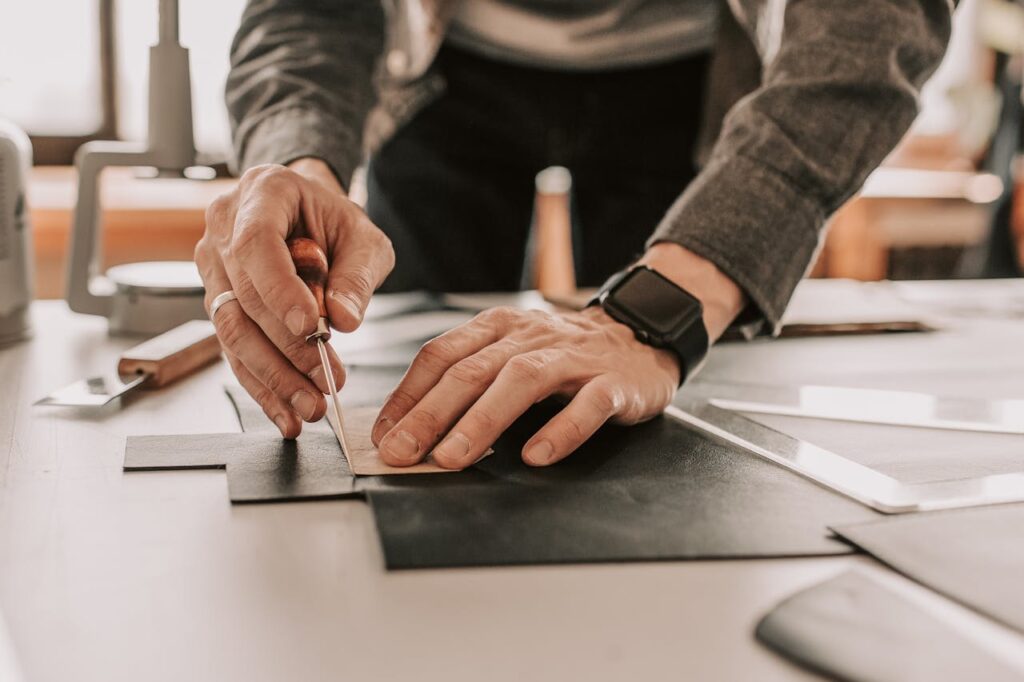 A Close-Up Shot of a Leatherworker Using a Stitching Awl